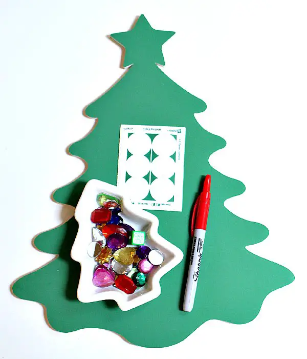 Christmas tree paper cutout, a marker, and beads