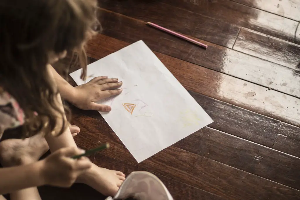 a kid doodling on a paper